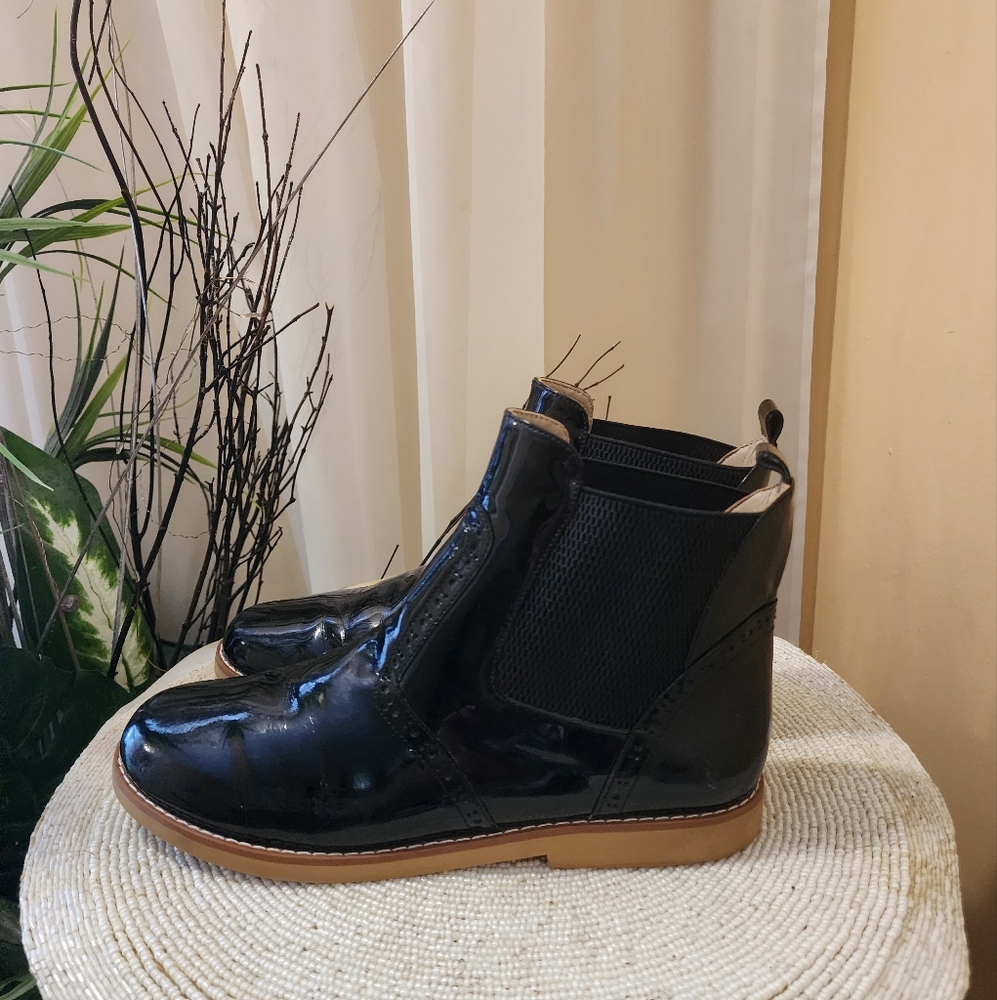 Elephantito patent leather ankle booties with brogue accent.Flat heel size 6